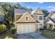 Charming two-story home with a manicured lawn, a white garage door, and mature trees in background at 3277 Wyesham Cir, Duluth, GA 30096