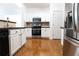 Bright kitchen with stainless steel appliances, dark countertop, and white cabinets at 3277 Wyesham Cir, Duluth, GA 30096