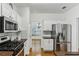 Well-lit kitchen with stainless steel appliances, white cabinets, and tile backsplash at 3277 Wyesham Cir, Duluth, GA 30096