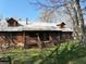 Quaint log cabin with a metal roof and a charming front porch with wooden features at 512 E Valley Ne Rd, Rydal, GA 30171