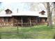 Inviting log cabin with a metal roof and front porch with wooden railing and stairs at 512 E Valley Ne Rd, Rydal, GA 30171