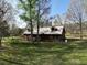 Scenic log cabin with a metal roof surrounded by trees and a lush green lawn at 512 E Valley Ne Rd, Rydal, GA 30171