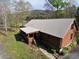 Beautiful log home with a metal roof, screened porch, and stone pathway surrounded by greenery at 512 E Valley Ne Rd, Rydal, GA 30171