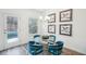 Dining area featuring a glass table with plush blue chairs and backyard views at 939 Brittfield Way, Loganville, GA 30052