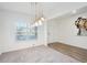 Sunlit dining room with chandelier lighting and hardwood floors near a front-facing window at 939 Brittfield Way, Loganville, GA 30052