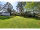 Expansive backyard featuring a lush lawn with mature trees and partial fencing at 863 Birch St, Forest Park, GA 30297