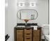 Bathroom with a dual sink vanity featuring black countertop and oval mirror at 863 Birch St, Forest Park, GA 30297