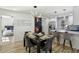 Dining area with modern light fixtures, an adjacent open kitchen, and natural light at 863 Birch St, Forest Park, GA 30297