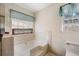 Bathroom featuring a soaking tub with tile surround, window, and toilet at 100 Cowan Trl, Stockbridge, GA 30281