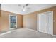 Bedroom with tan walls, ceiling fan, window, closet, and light-colored carpet at 100 Cowan Trl, Stockbridge, GA 30281