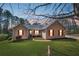 Charming ranch-style home with a well-manicured lawn, inviting curb appeal, and a cozy front porch at dusk at 100 Cowan Trl, Stockbridge, GA 30281