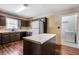 Kitchen features dark cabinets, an island, and access to the laundry room at 100 Cowan Trl, Stockbridge, GA 30281