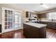 Eat-in kitchen features dark cabinets, doors to the exterior, and white countertops at 100 Cowan Trl, Stockbridge, GA 30281