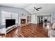 Open living room with hardwood floors, fireplace, vaulted ceilings, and a view into the dining room at 100 Cowan Trl, Stockbridge, GA 30281