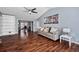 Inviting living room with hardwood floors, ceiling fan, gray couch, and artwork at 100 Cowan Trl, Stockbridge, GA 30281