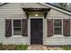 Close-up of the front door with a security screen, shuttered windows, and simple covered porch at 3020 Harold Se Ave, Atlanta, GA 30316