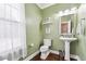 Powder room with green walls, dark floors, and natural light at 3725 Sycamore Bnd, Decatur, GA 30034