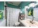 A modest bathroom with a combination shower-tub with a curtain, toilet, sink, and laundry machines at 4751 Bill Cheek Rd, Auburn, GA 30011