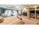 A large main bedroom featuring a tray ceiling, ceiling fan, fireplace, built-ins, and access to the exterior at 4751 Bill Cheek Rd, Auburn, GA 30011