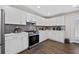 Stylish kitchen features white cabinets, stainless steel appliances, and grey backsplash at 7178 Cavender Sw Dr, Atlanta, GA 30331