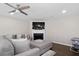 Comfortable living room featuring a fireplace, large TV, and contemporary ceiling fan at 7178 Cavender Sw Dr, Atlanta, GA 30331