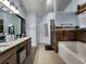 Bright bathroom features a double vanity, tiled flooring, soaking tub, and separate glass enclosed shower at 2702 Brookefield Nw Ln, Kennesaw, GA 30152