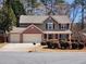 Charming two-story home featuring a three-car garage, landscaped yard, and inviting front porch with decorative wreath at 2702 Brookefield Nw Ln, Kennesaw, GA 30152