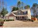 Well-maintained two-story home showcasing a three-car garage, lush landscaping, and a welcoming front porch with red accents at 2702 Brookefield Nw Ln, Kennesaw, GA 30152