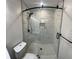 Modern bathroom with a glass-enclosed shower, mosaic tile floor, and sleek, dark hardware at 1027 Goza Rd, Fayetteville, GA 30215