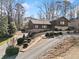 A winding driveway leads to this charming two-story house with stone accents and mature landscaping at 1905 Castleway Ne Ln, Atlanta, GA 30345