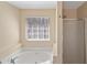 Bright bathroom featuring tub, standup shower, and vanity with ample natural light at 313 Sable Trace Pass, Acworth, GA 30102