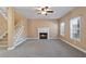 Inviting living room with a cozy fireplace, staircase, ceiling fan, and bright windows for natural light at 313 Sable Trace Pass, Acworth, GA 30102