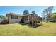 Backyard features a well-kept lawn, mature trees, screened porch, and a deck for outdoor enjoyment at 115 Heritage Cir, Mcdonough, GA 30253