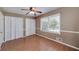 A well-lit bedroom showcasing hardwood floors, a ceiling fan, and bright natural light from the large window at 115 Heritage Cir, Mcdonough, GA 30253