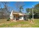 Quaint home featuring mature trees, grass lawn, and a covered front porch entry at 115 Heritage Cir, Mcdonough, GA 30253