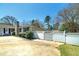 Well-maintained home featuring a stone chimney, light siding, and a white perimeter fence at 115 Heritage Cir, Mcdonough, GA 30253