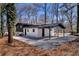 Charming home featuring a white brick exterior, dark trim, carport, and a spacious gravel driveway at 1785 Hammond Woods Sw Cir, Marietta, GA 30008