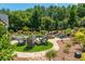 An inviting backyard features an outdoor fire pit surrounded by comfortable seating, a lush green lawn, and elegant landscaping at 201 Edwards Brook Ct, Canton, GA 30115