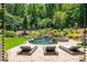 Beautiful backyard oasis featuring a luxurious pool, waterfall, and meticulously manicured landscaping at 201 Edwards Brook Ct, Canton, GA 30115