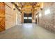 Large, open garage space with brick walls, exposed beams, and a modern lighting fixture at 201 Edwards Brook Ct, Canton, GA 30115