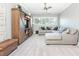 Cozy living room with a large sectional sofa, custom barn door cabinet, and plush carpeting at 201 Edwards Brook Ct, Canton, GA 30115