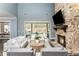 Bright open-concept living room boasts a stone fireplace, built-in shelving, and sliding glass doors at 201 Edwards Brook Ct, Canton, GA 30115