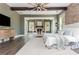 Spacious main bedroom featuring a stone fireplace, ceiling fan, exposed beams, and hardwood floors at 201 Edwards Brook Ct, Canton, GA 30115