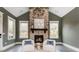 Bright sitting area with stone fireplace, wood mantle, and natural light from the adjacent windows at 201 Edwards Brook Ct, Canton, GA 30115