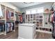 Walk-in closet complete with custom shelving, storage, hanging racks, and center island for accessories at 201 Edwards Brook Ct, Canton, GA 30115