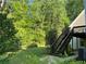 Yard with lush greenery, stairs leading up to the back of the house, and a peaceful setting at 3550 Gravitt Rd, Cumming, GA 30040