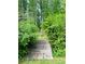 Charming wooden bridge leading to a peaceful wooded area adds character to the backyard at 3550 Gravitt Rd, Cumming, GA 30040
