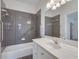 Updated bathroom with grey tile, white vanity, and a shower-tub combination at 3550 Gravitt Rd, Cumming, GA 30040