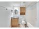 Bright bathroom features a wooden vanity, storage cabinet, and a shower-tub combination at 3550 Gravitt Rd, Cumming, GA 30040