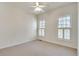 Bright bedroom features plush carpet, a ceiling fan, and shuttered windows with natural light at 3550 Gravitt Rd, Cumming, GA 30040
